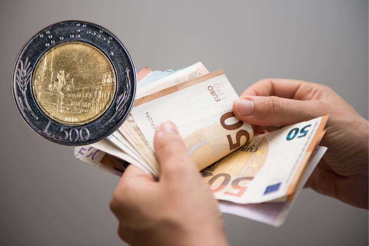 una persona che tiene in mano tanti soldi e vicino una moneta da 500 lire