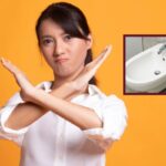 donna che dice di no con le braccia incrociate a X e nel riquadro un bidet