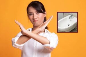 donna che dice di no con le braccia incrociate a X e nel riquadro un bidet