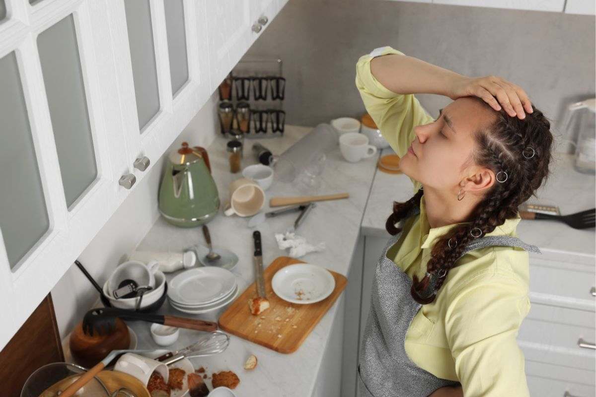 una ragazza disperata per la cucina in disordine