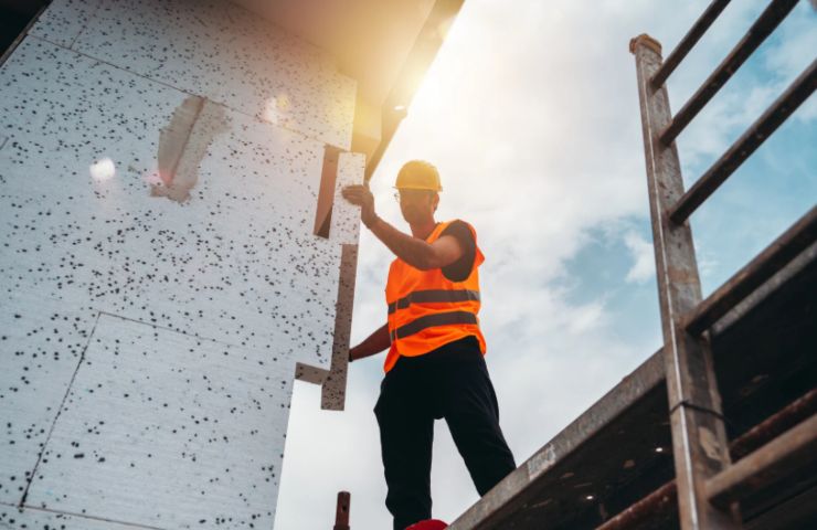 operai che installa il cappotto termico fuori da un edificio