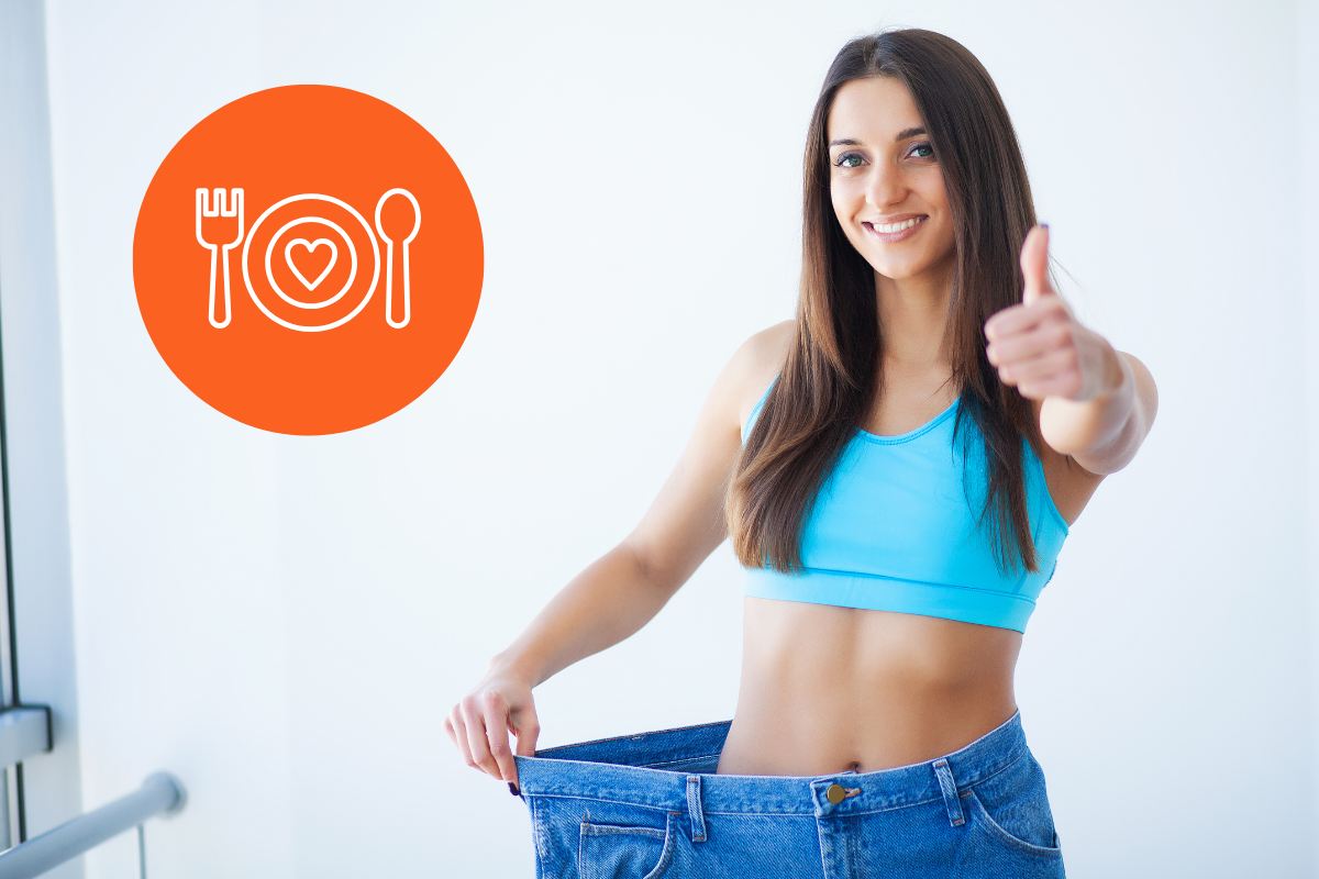 Una ragazza in forma contenta che indossa dei pantaloni di una taglia molto più grande