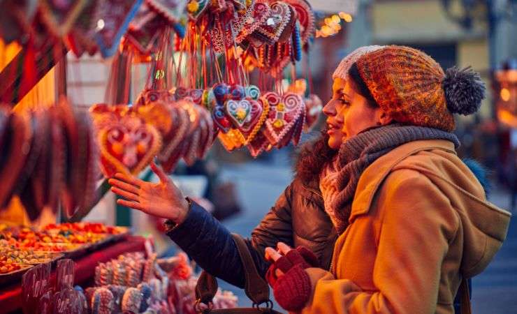 due persone che osservano degli oggetti ai mercatini di Natale