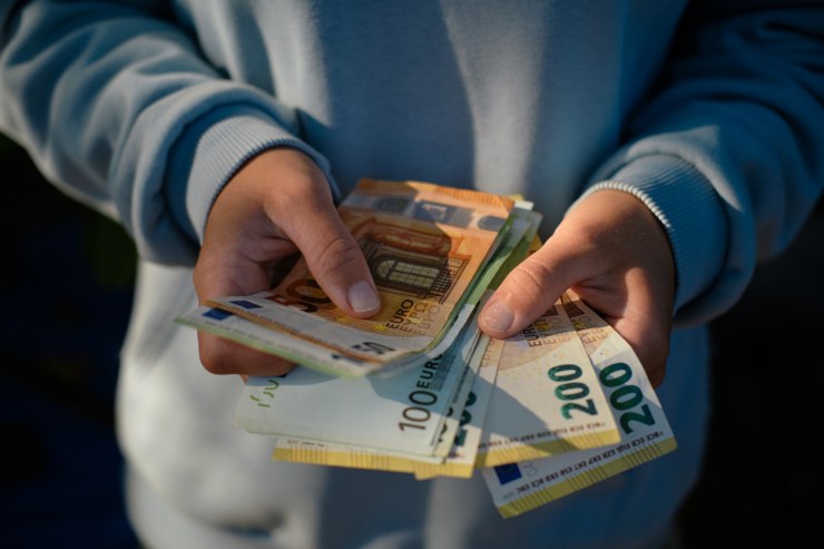 Una persona con delle banconote in mano che le conta