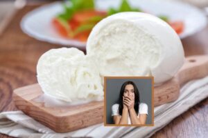 mozzarella su un tagliere di legno e donna spaventata con le mani sulla bocca