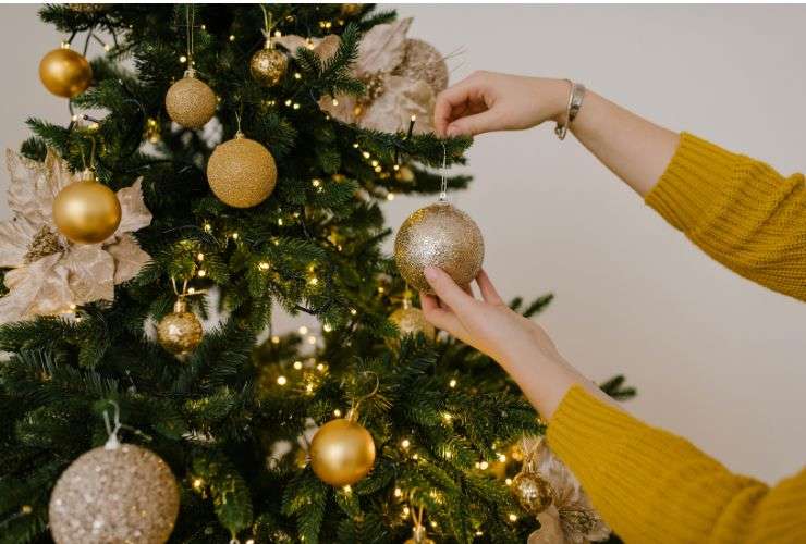 una persona fa l'albero di natale