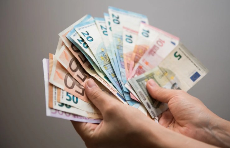 persona che tiene nelle mani tante banconote di euro
