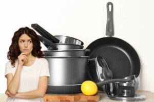 delle pentole e delle padelle pulite ed una persona dubbiosa sulla sinistra