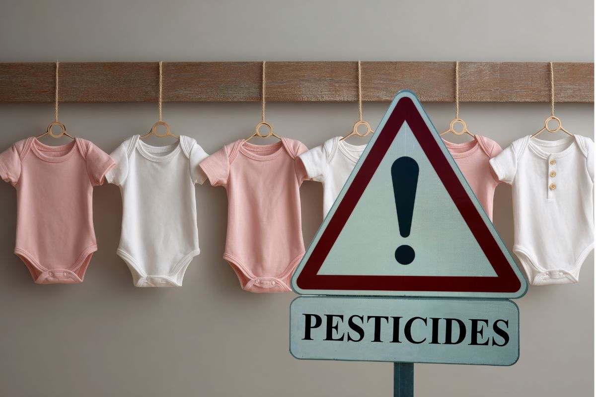 vestiti neonati e un segnale con la parola pesticidi