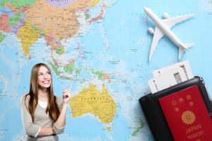 Una cartina geografica con una ragazza che indica ed un aeroplanino giocattolo ed un passaporto con dei biglietti