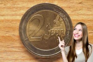 moneta 2 euro e donna che indica