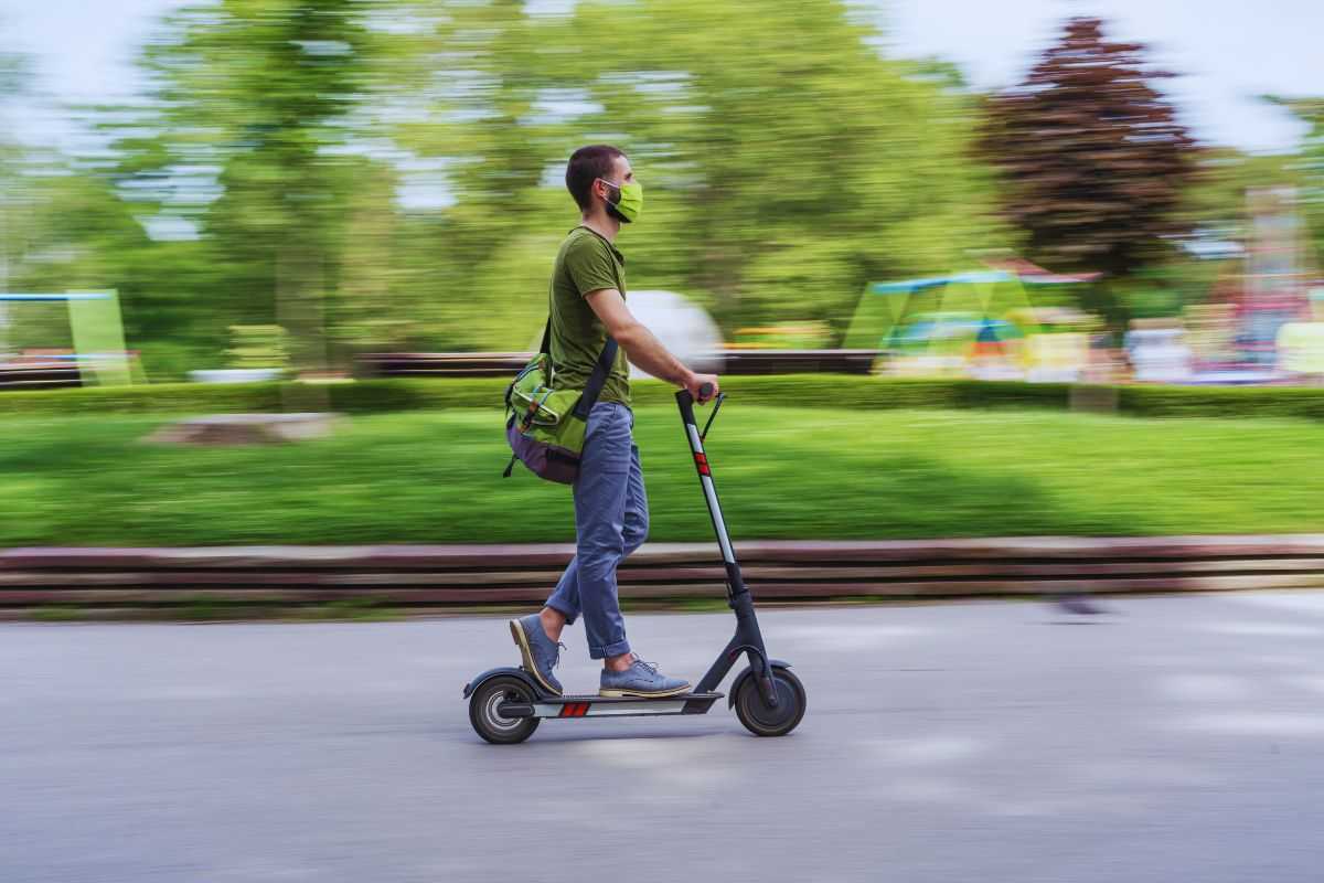 Uomo che viaggia su monopattino elettrico