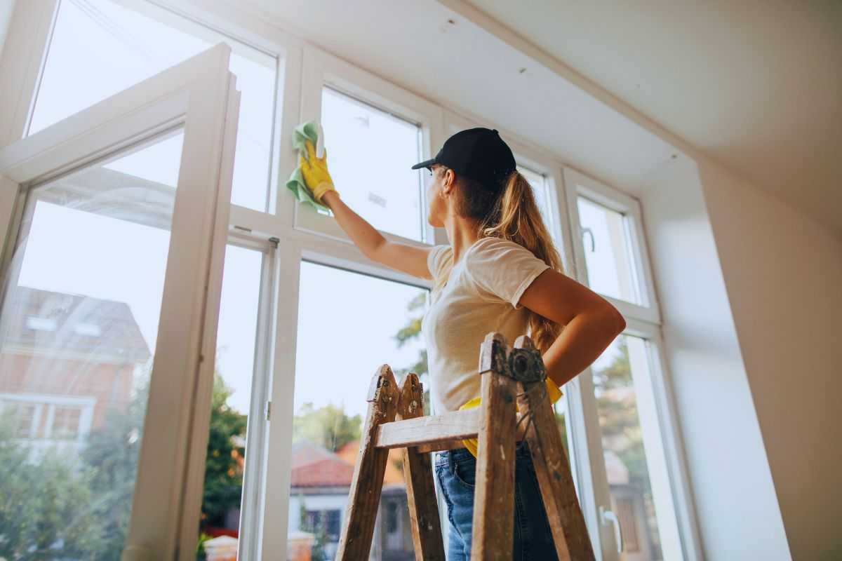 Donna che pulisce finestre