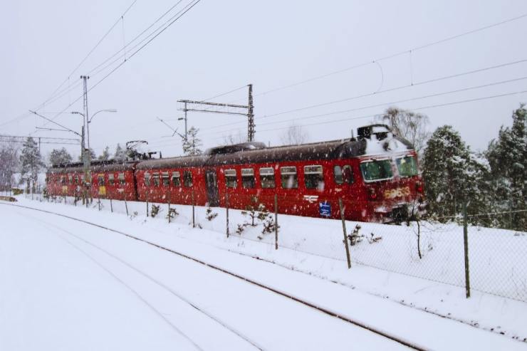 Treno che sfreccia in mezzo ad un paesaggio innevato