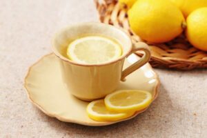 Tazza con acqua e fette di limone, limoni