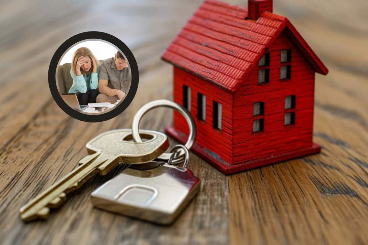 casetta in miniatura con accanto delle chiavi e due persone preoccupate con le mani sulla fronte