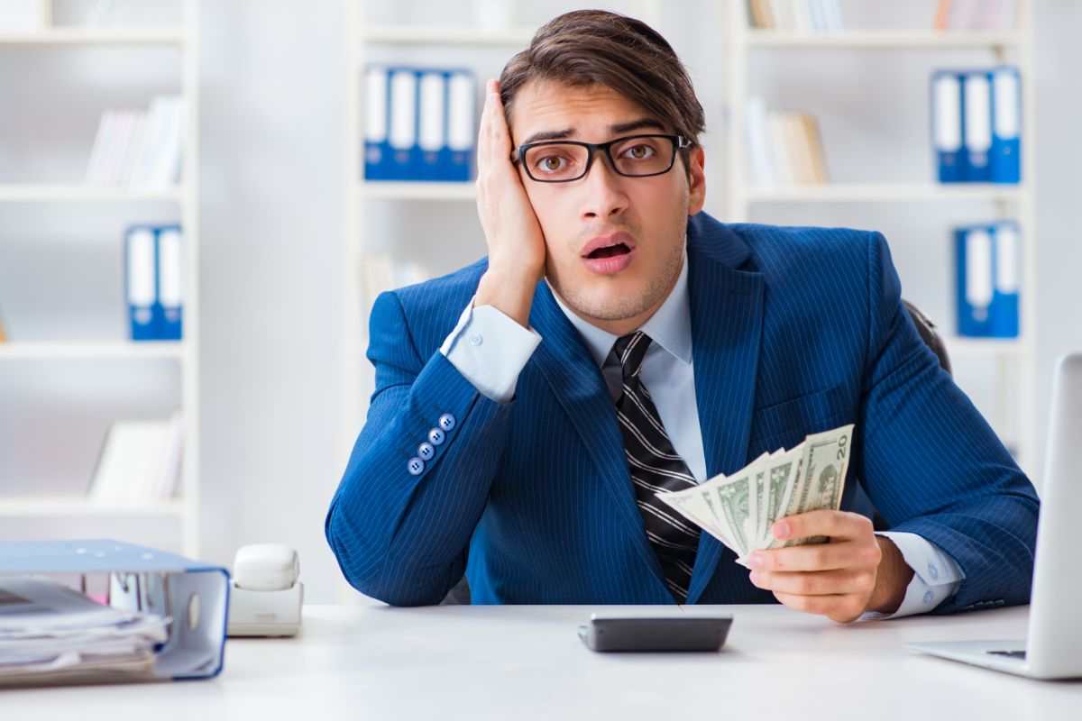 uomo disperato con soldi in mano 