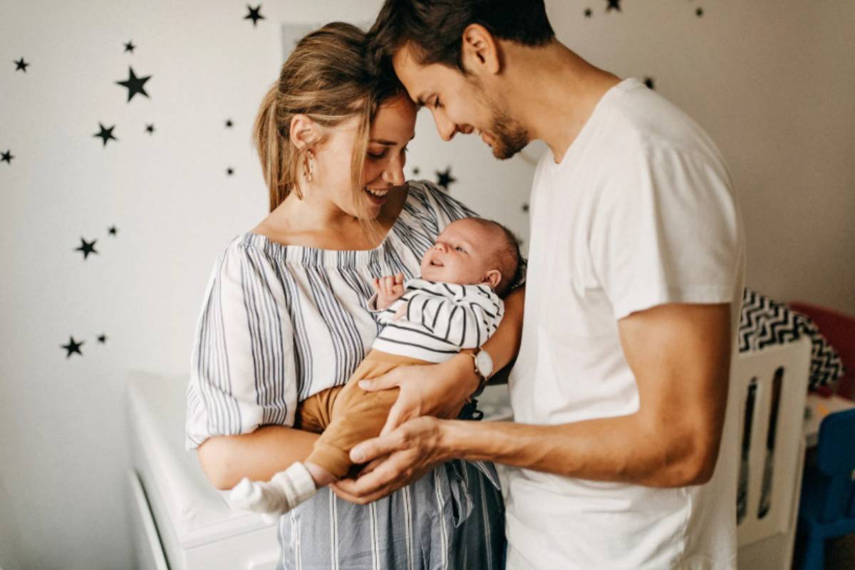uomo e donna felici con in braccio un neonato
