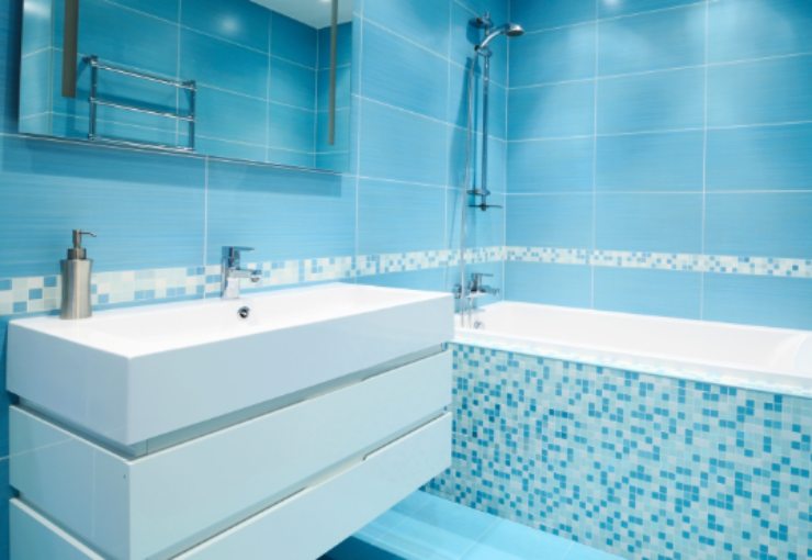 bagno con piastrelle azzurre alla pareti e sulla vasca