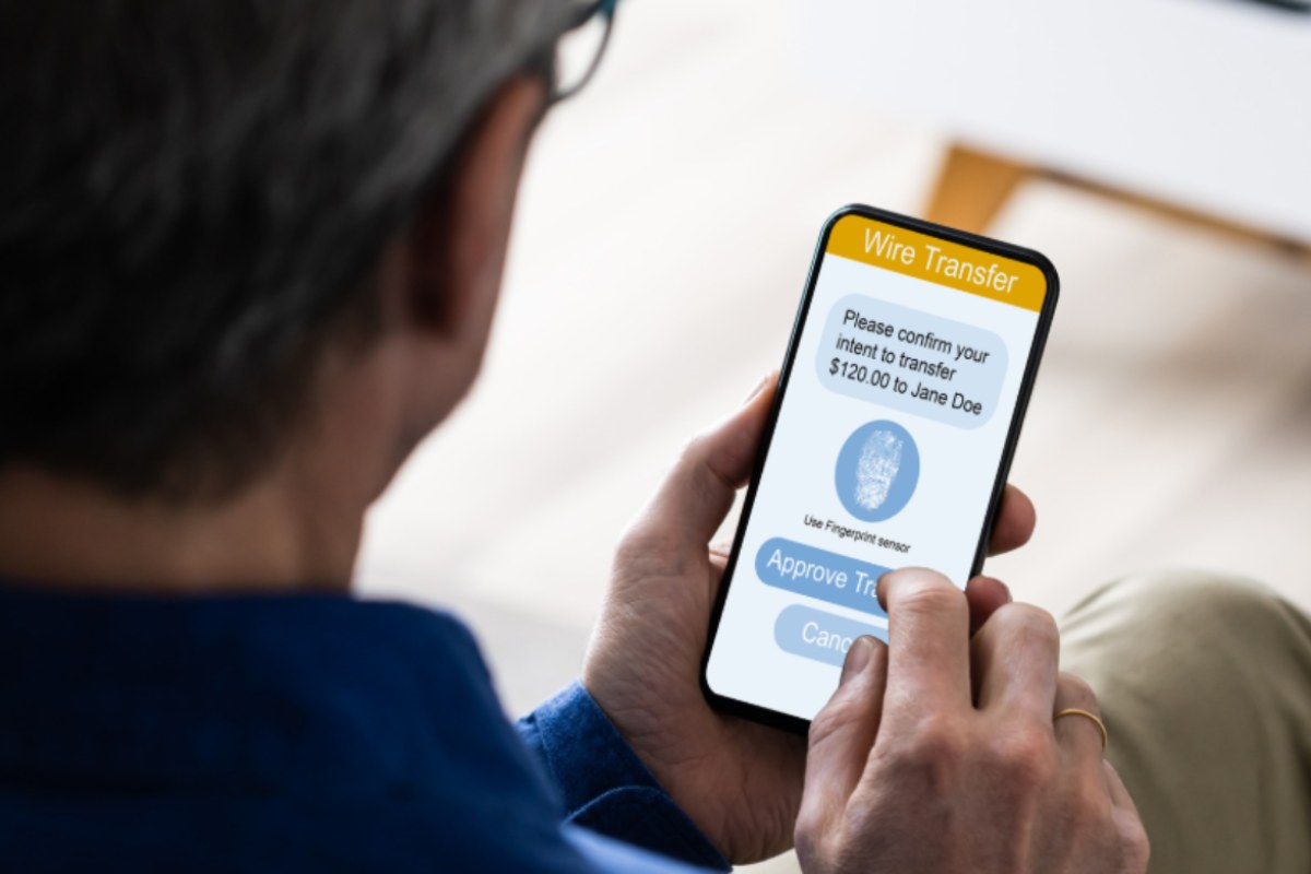 uomo che fa un bonifico con il cellulare