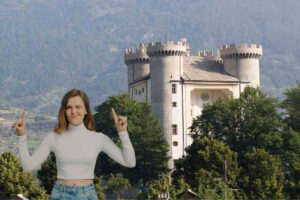 Castello di Aymavilles ed una ragazza che lo indica