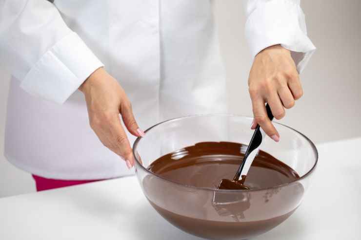 Uno chef che gira del cioccolato sciolto