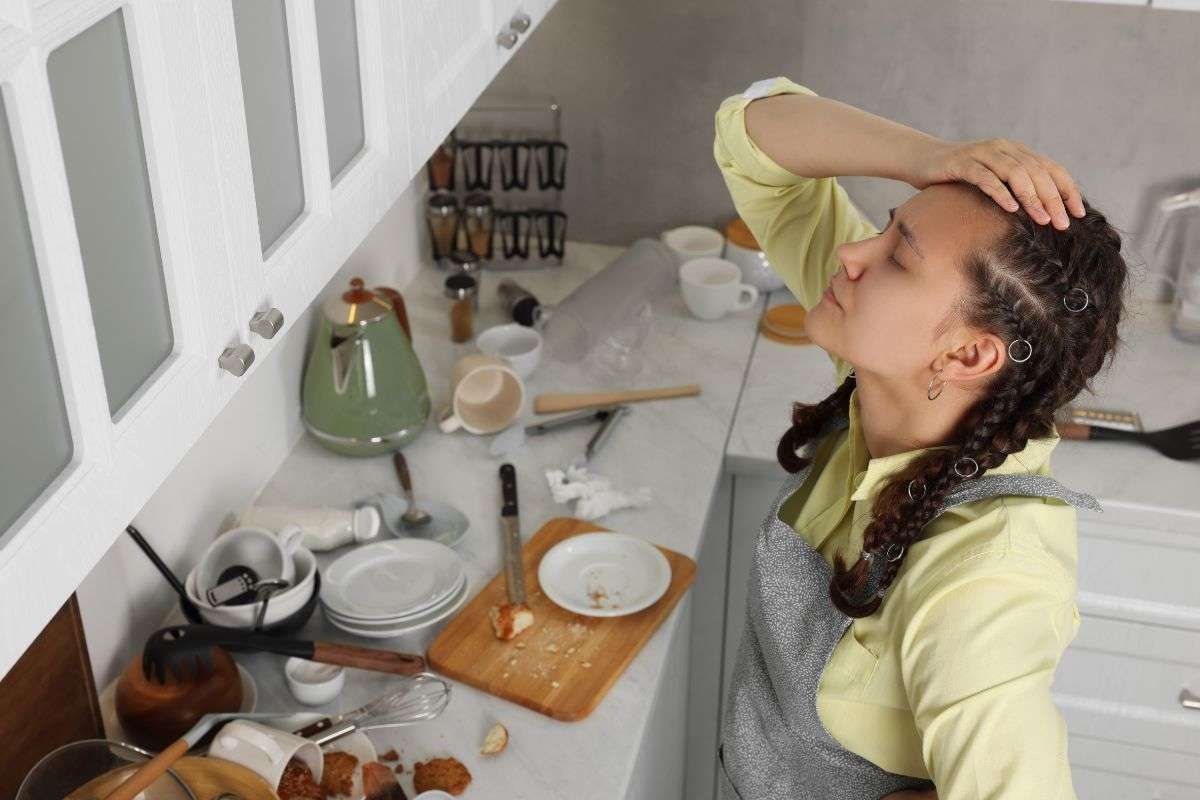 una persona disperata e una cucina in disordine