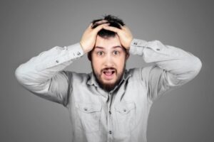 uomo disperato con le mani nei capelli