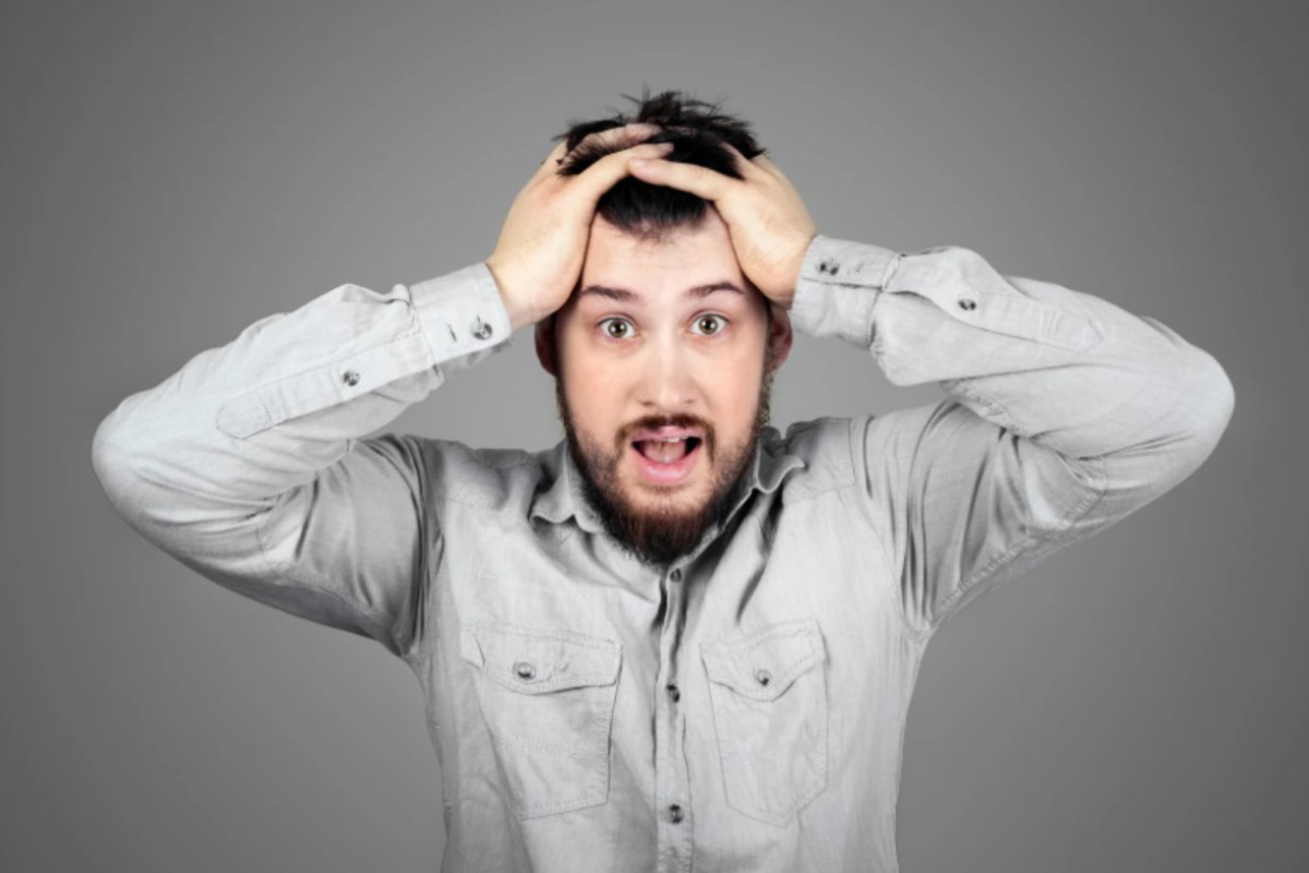 uomo disperato con le mani nei capelli