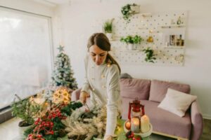 donna che mette gli addobbi natalizi in casa