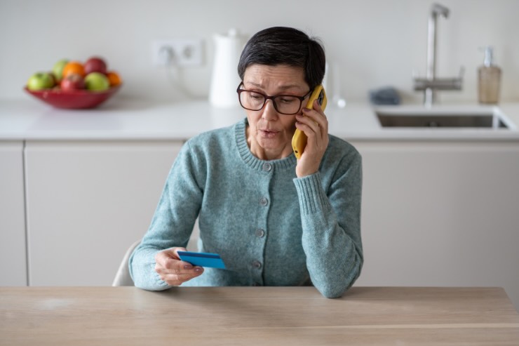 donna che parla al telefono con carta in mano