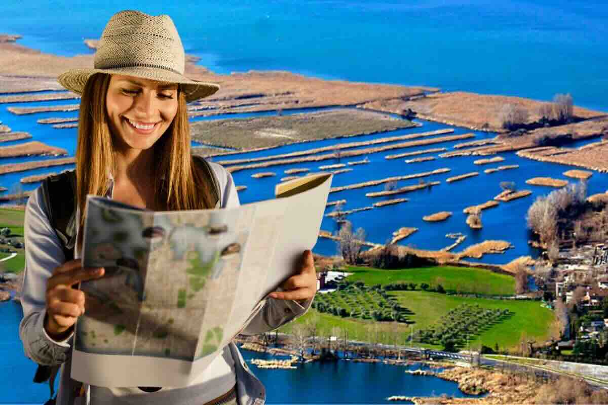 Donna con cartina, lago dietro di lei