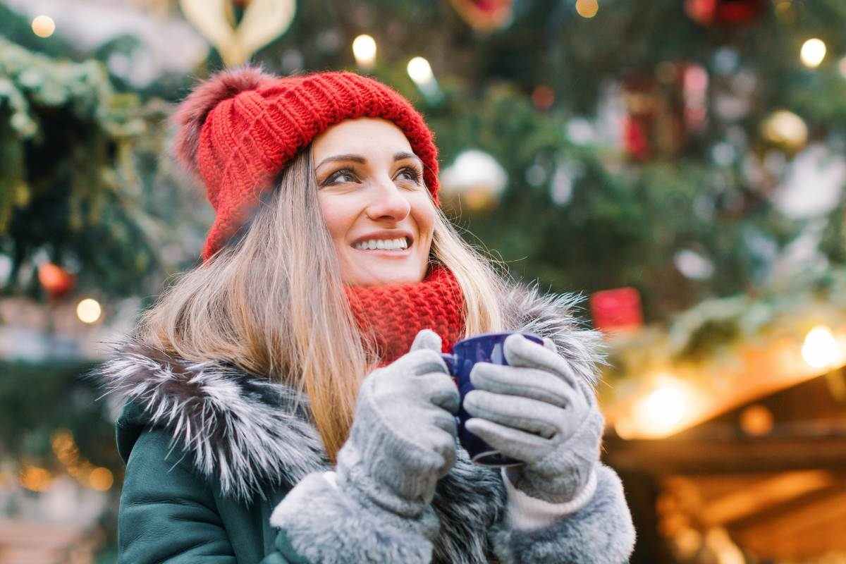 ragazza all'aria aperta con una tazza calda in mano