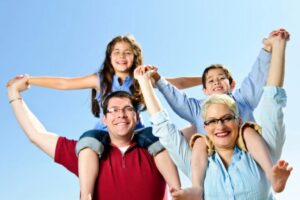 genitori felici che tengono sulle spalle un bambino e una bambina