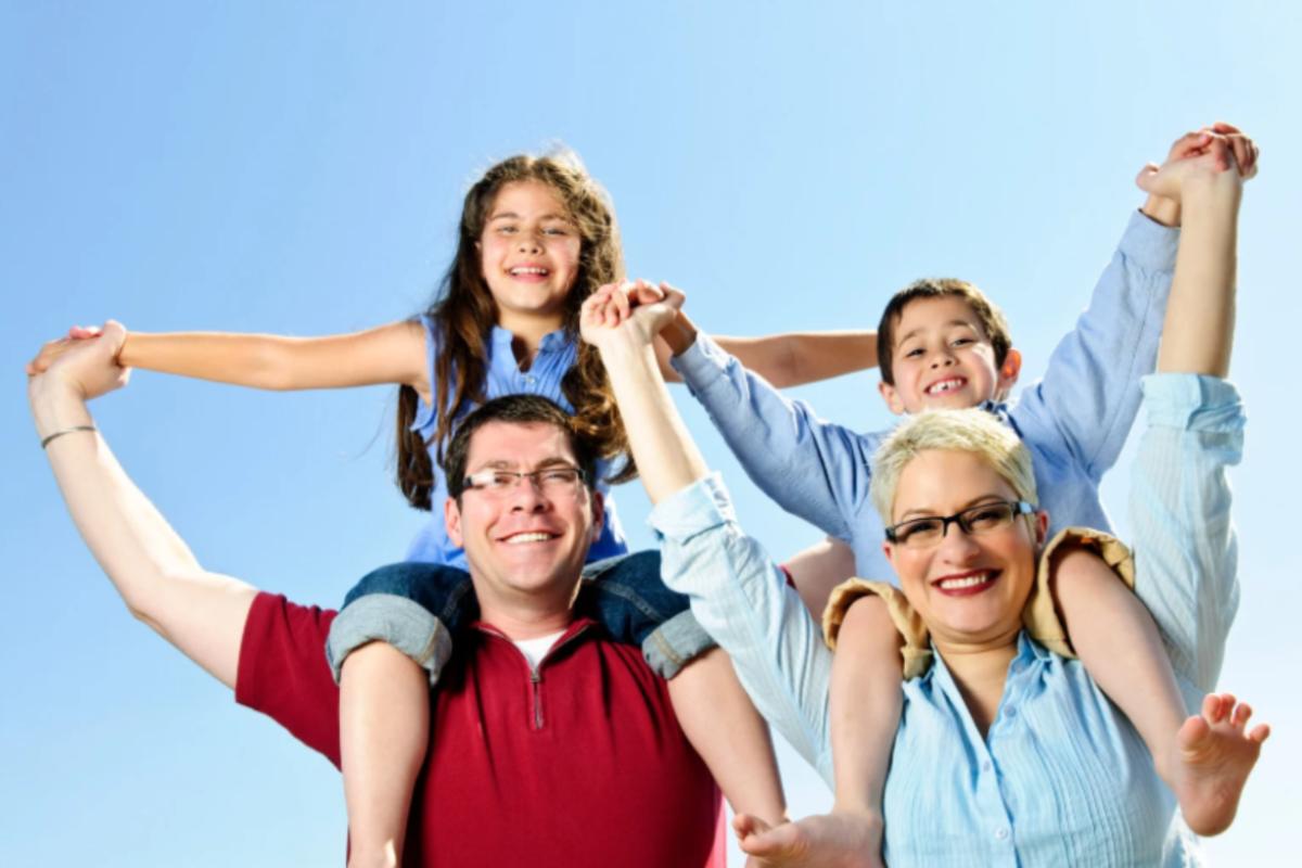 genitori felici che tengono sulle spalle un bambino e una bambina