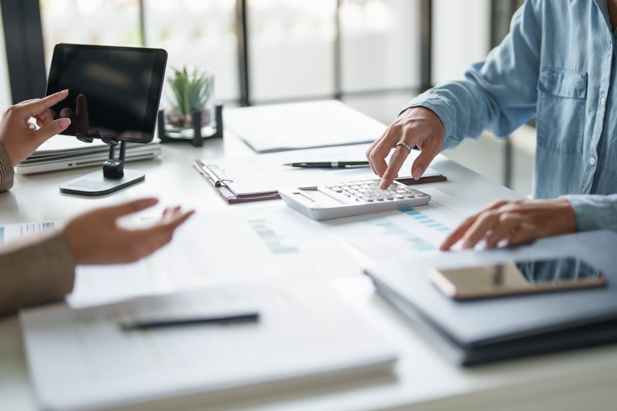 mani di persone, fogli, calcolatrice