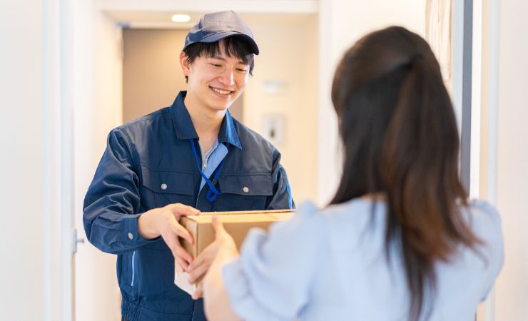 corriere che prende pacco da donna alla porta 