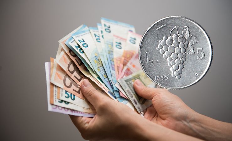 una persona che tiene in mano i soldi e la moneta vicino