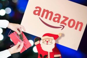 donna con regalo, logo amazon e sagoma babbo natale