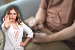 uomo con telefono in mano e donna che fa stop con le mani