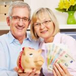 due signori anziani con salvadanaio e banconote