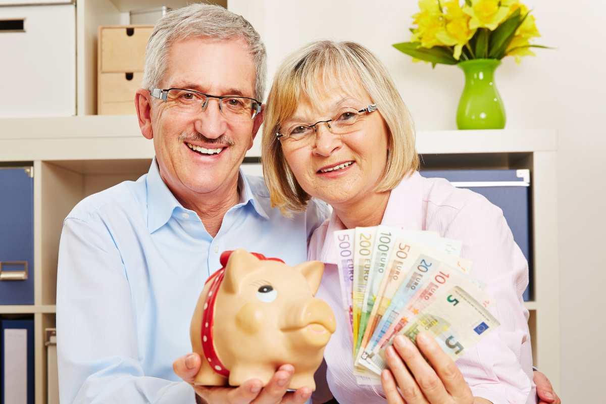 due signori anziani con salvadanaio e banconote