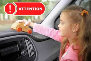 bambina in auto e simbolo "attenzione"