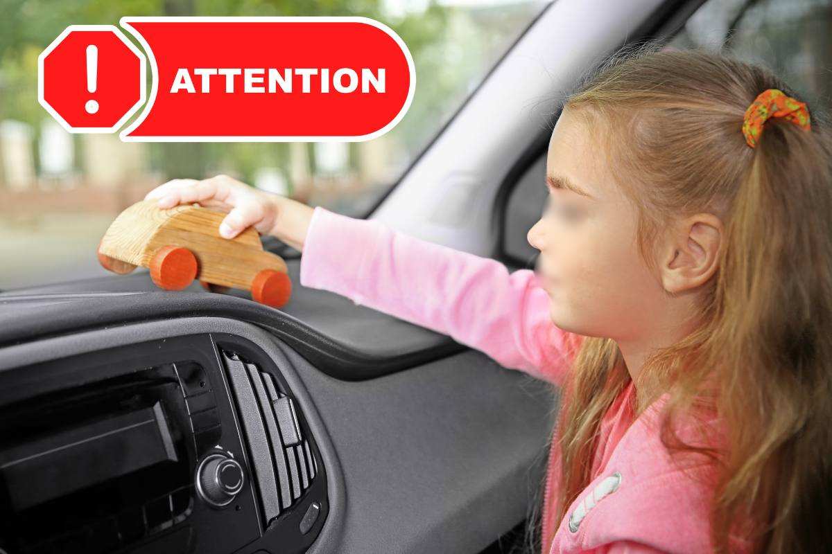 bambina in auto e simbolo "attenzione"