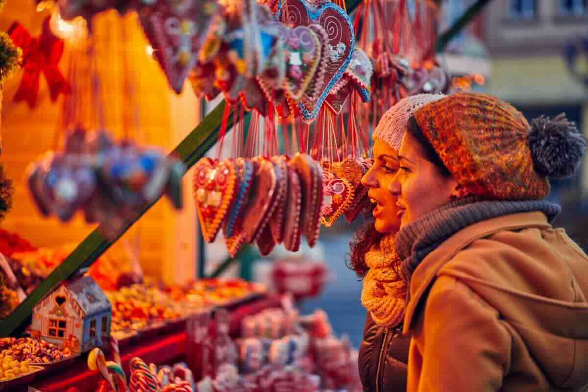 Due donne guardano una bancarella di Natale
