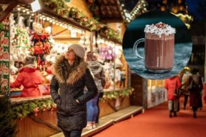 una ragazza che passeggia tra i mercatini di natale e una cioccolata calda