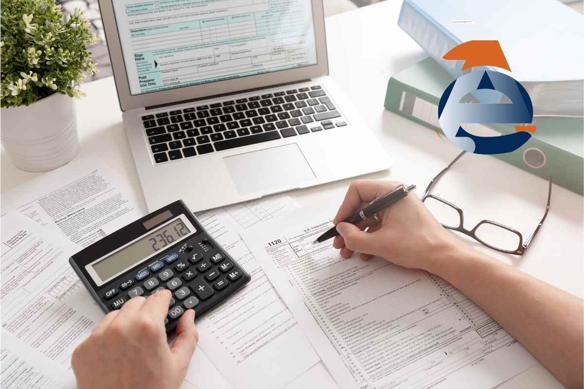 una persona che sta lavorando al computer e con una calcolatrice vicino