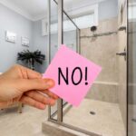 mano che mantiene post-it con la scritta no e bagno moderno