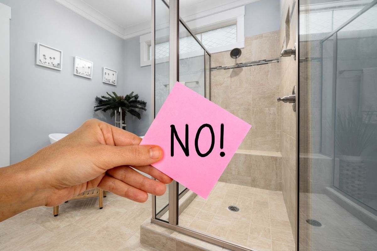 mano che mantiene post-it con la scritta no e bagno moderno