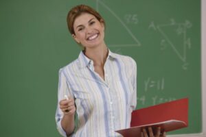 professoressa che sorride davanti alla lavagna